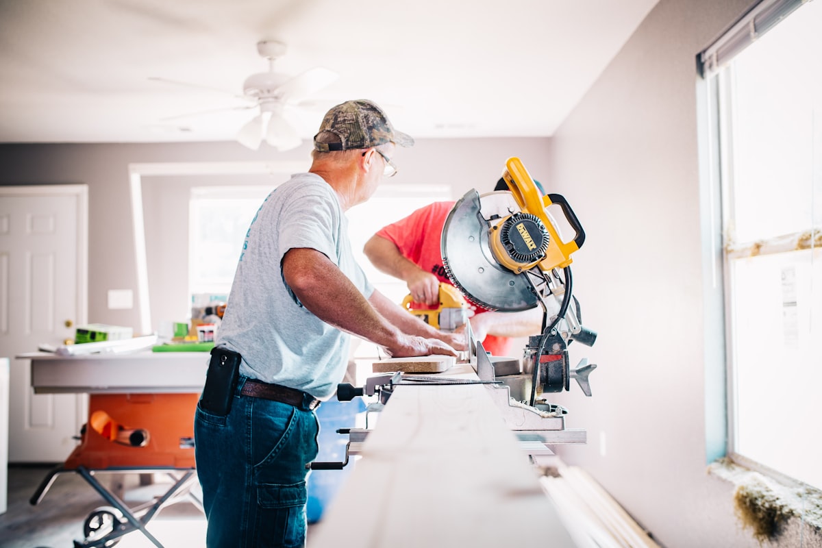 Carpenters cutting timber on a mitre saw during a home renovation